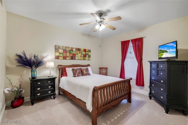 bedroom with a ceiling fan, light carpet, and baseboards