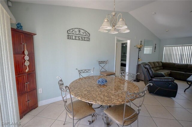 tiled dining room featuring an inviting chandelier and vaulted ceiling