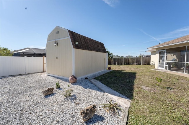 view of side of home with a sunroom, a storage unit, and a lawn