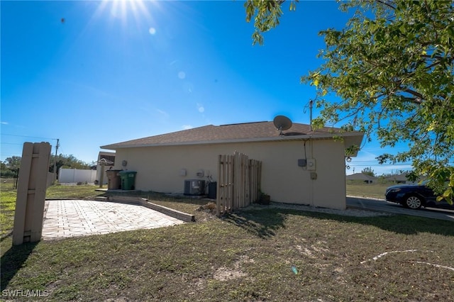 back of house with a lawn, cooling unit, and a patio