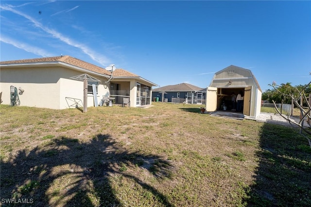 view of yard with a sunroom and a storage unit