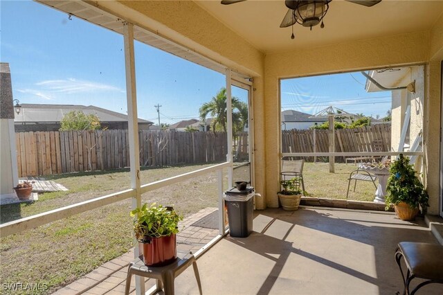 unfurnished sunroom featuring ceiling fan