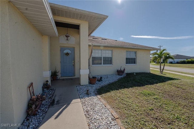 entrance to property featuring a yard