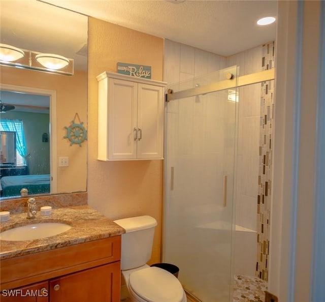 bathroom featuring vanity, toilet, and a shower with shower door