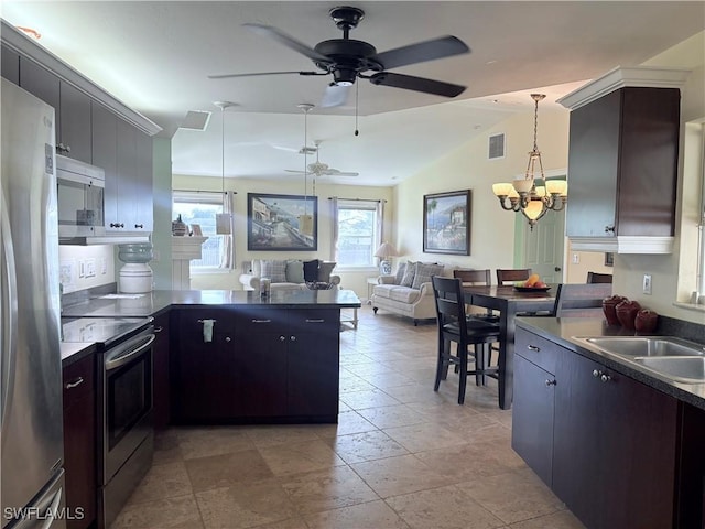 kitchen featuring pendant lighting, lofted ceiling, stainless steel appliances, and a wealth of natural light