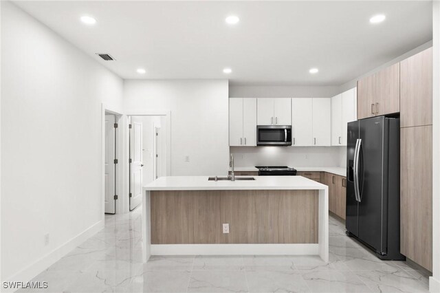 kitchen featuring black stove, sink, refrigerator with ice dispenser, an island with sink, and white cabinets