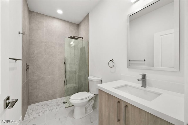 bathroom with vanity, toilet, and a tile shower