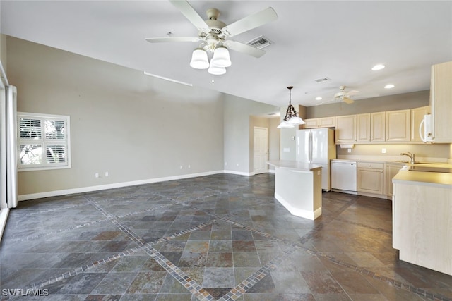 kitchen featuring pendant lighting, ceiling fan, a center island, and white appliances