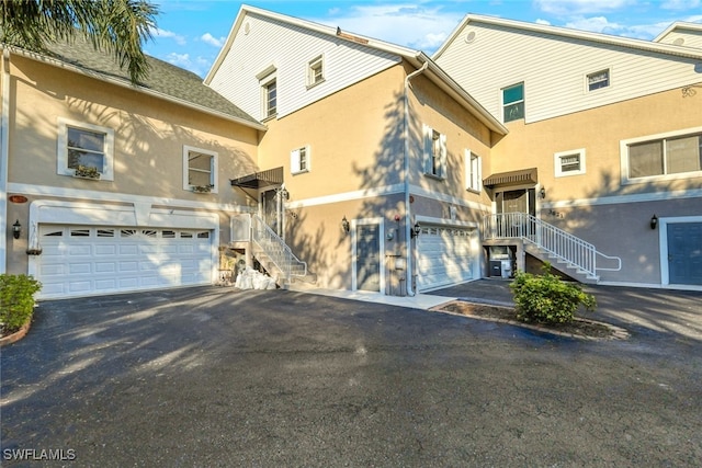 exterior space featuring central air condition unit and a garage