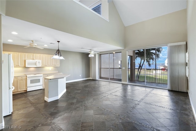 kitchen featuring ceiling fan, a center island, white appliances, and hanging light fixtures