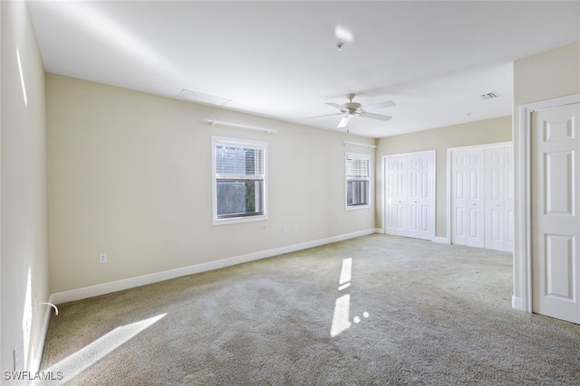 carpeted spare room with ceiling fan