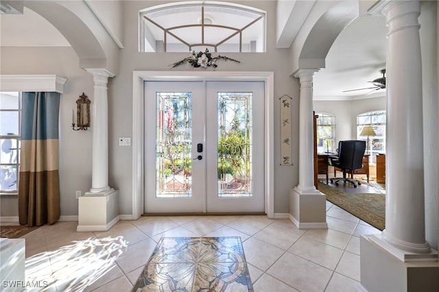 entrance foyer with ceiling fan, light tile patterned flooring, french doors, and crown molding