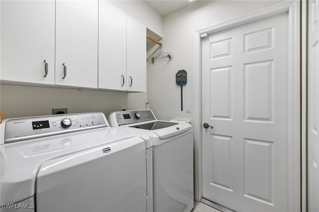 laundry room with independent washer and dryer and cabinets