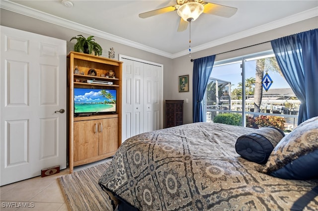 tiled bedroom with a closet, ceiling fan, and ornamental molding