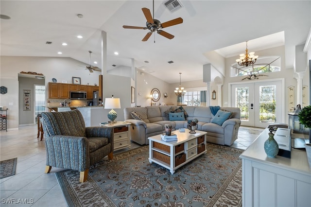 tiled living room with ornamental molding, french doors, high vaulted ceiling, and ceiling fan with notable chandelier