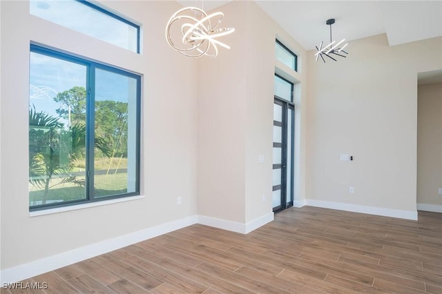 unfurnished room featuring an inviting chandelier and a healthy amount of sunlight