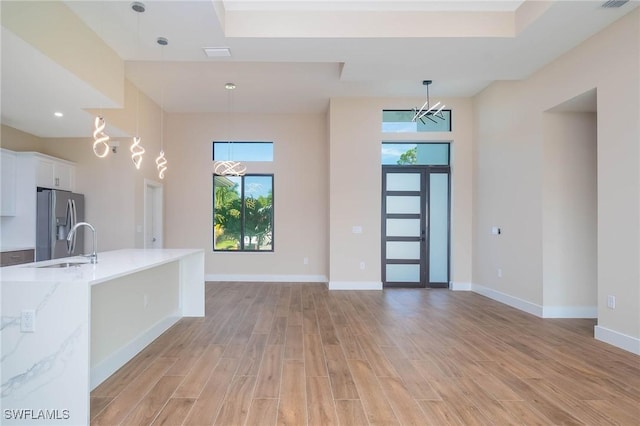 foyer entrance featuring sink, a towering ceiling, and a chandelier