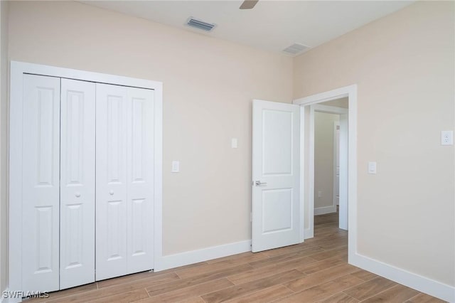 unfurnished bedroom with ceiling fan and a closet