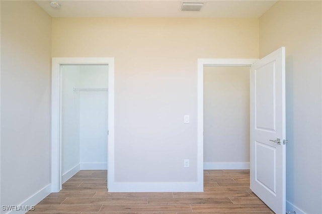 unfurnished bedroom with a walk in closet and a closet