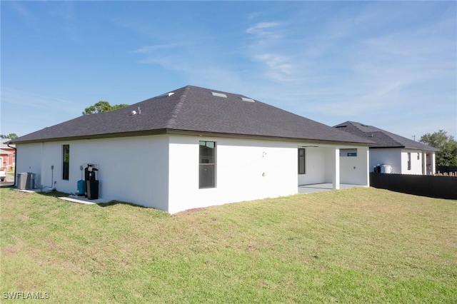 back of property featuring central AC unit and a yard