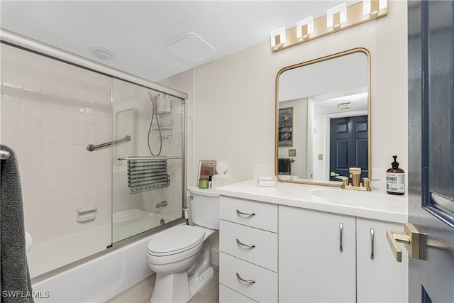 full bathroom with vanity, toilet, and bath / shower combo with glass door