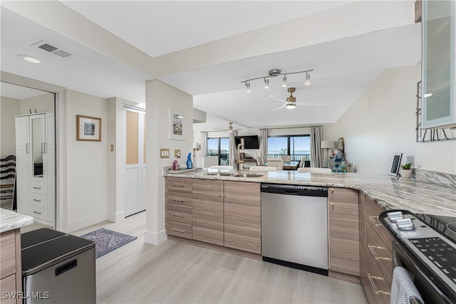 kitchen featuring sink, ceiling fan, light stone countertops, appliances with stainless steel finishes, and light hardwood / wood-style floors