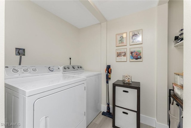 laundry room featuring washer and clothes dryer and light hardwood / wood-style flooring