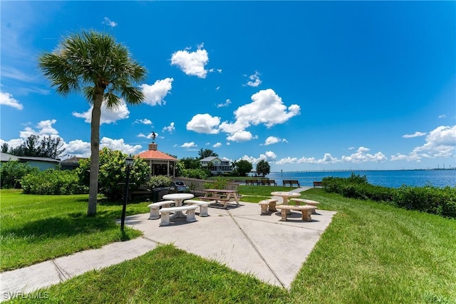 view of home's community with a gazebo, a patio, a lawn, and a water view