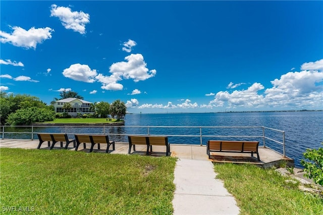 dock area with a yard and a water view