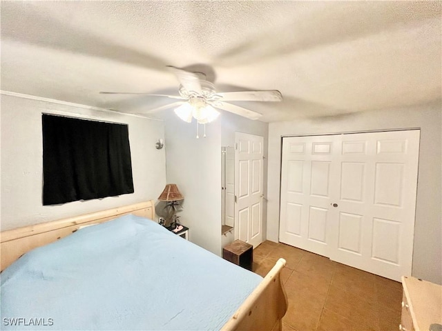 tiled bedroom with a textured ceiling, a closet, and ceiling fan