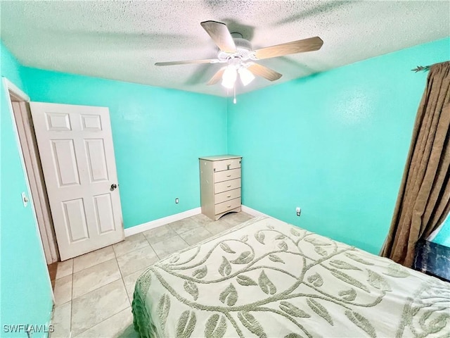 tiled bedroom featuring a textured ceiling and ceiling fan