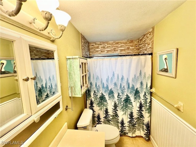 bathroom with tile patterned flooring, a shower with curtain, a textured ceiling, and toilet