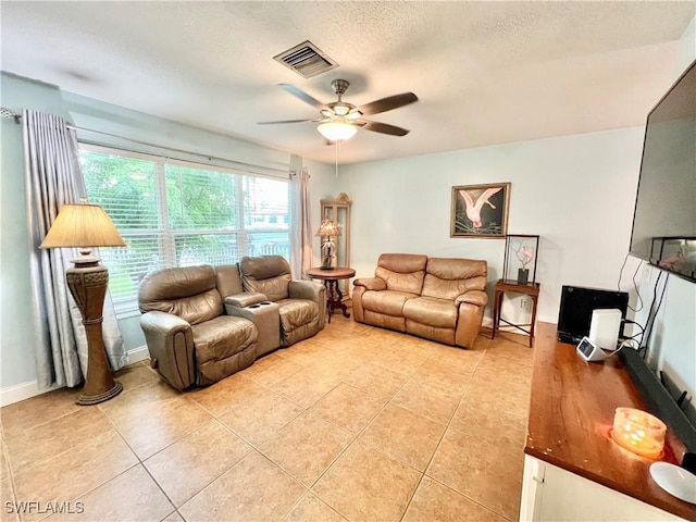 tiled living room with ceiling fan and a textured ceiling