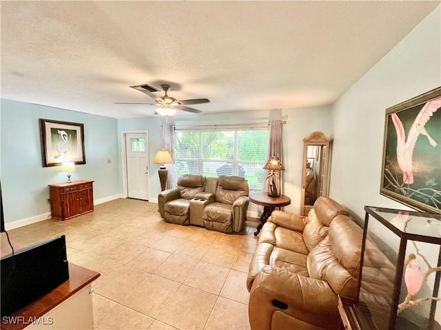 living room featuring ceiling fan, light tile patterned floors, and a textured ceiling