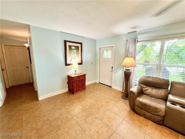 sitting room featuring a textured ceiling and light tile patterned flooring