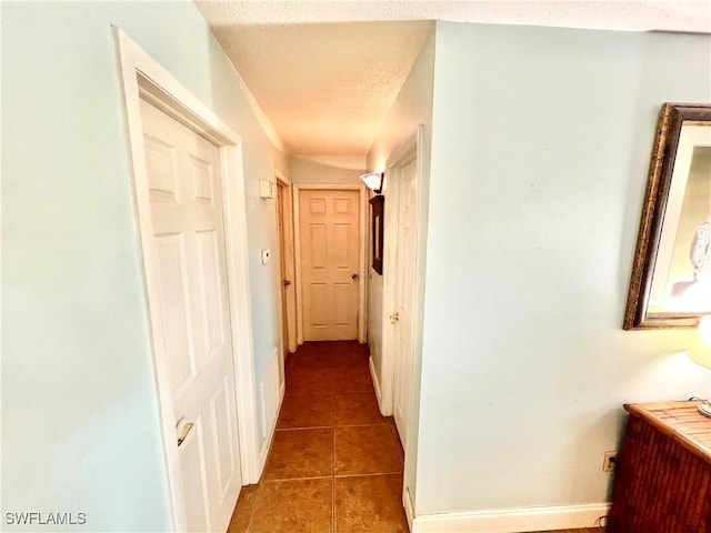 hallway featuring dark tile patterned flooring