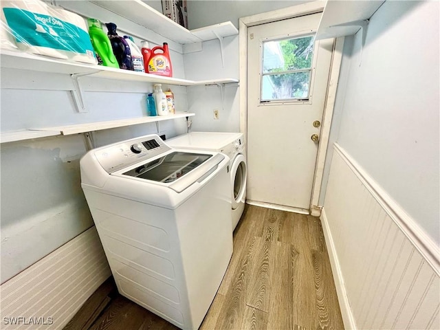 clothes washing area with separate washer and dryer and light hardwood / wood-style floors