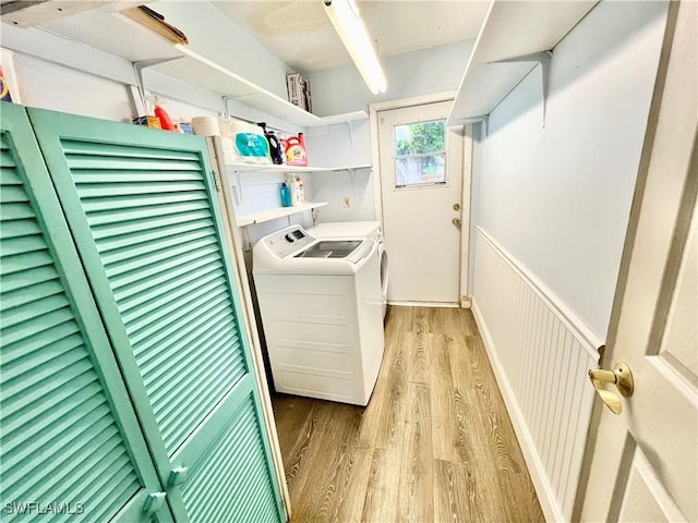 clothes washing area featuring washer and dryer and light hardwood / wood-style floors