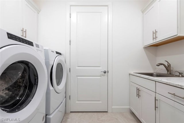 laundry room with light tile patterned flooring, cabinets, sink, and washing machine and clothes dryer