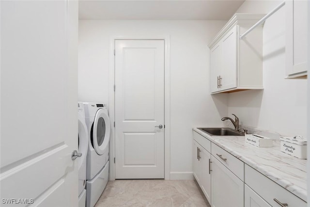 laundry area featuring light tile patterned flooring, cabinets, sink, and washing machine and clothes dryer