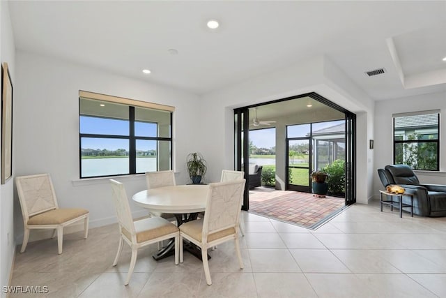 dining room featuring a water view and light tile patterned floors