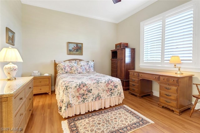 bedroom featuring crown molding and light hardwood / wood-style flooring