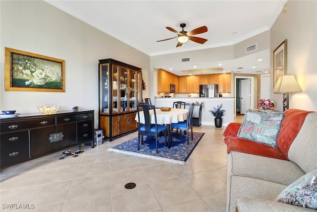 tiled dining room with ceiling fan and ornamental molding