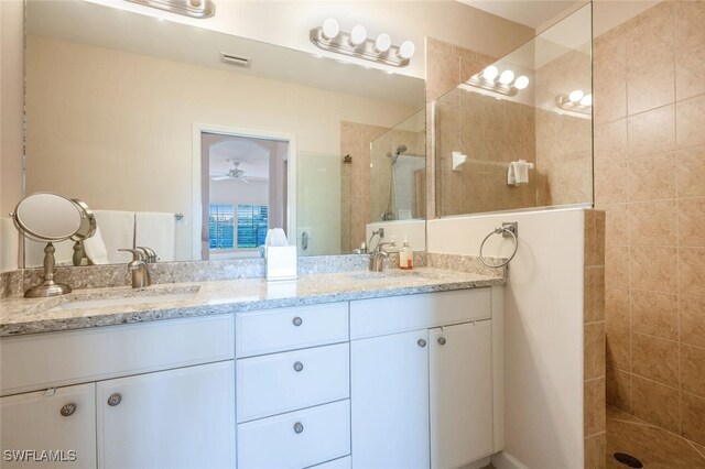 bathroom with vanity, ceiling fan, and tiled shower