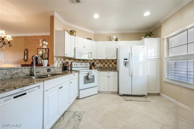 kitchen with white appliances, dark stone counters, sink, and white cabinets