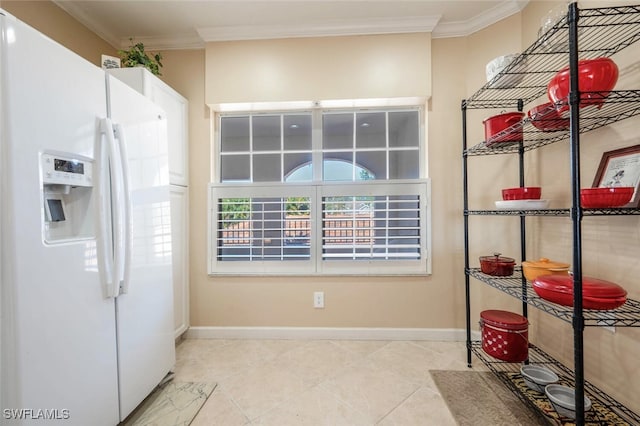 interior space with white cabinetry, light tile patterned floors, crown molding, and white fridge with ice dispenser