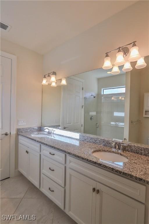 bathroom featuring tile patterned flooring, vanity, and a shower with shower door