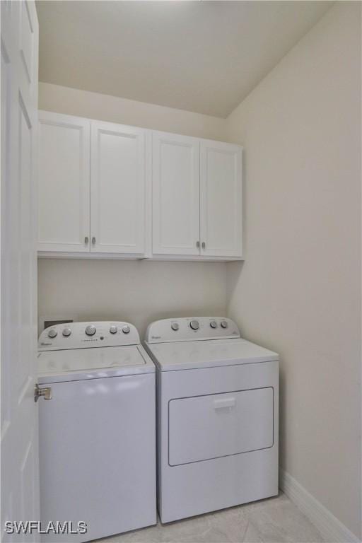 washroom with washing machine and clothes dryer and cabinets