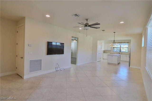 unfurnished living room featuring light tile patterned floors and ceiling fan with notable chandelier