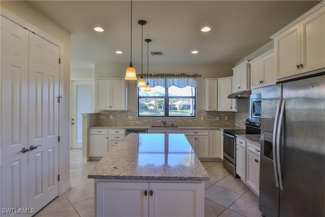 kitchen with white cabinetry, a center island, hanging light fixtures, stainless steel appliances, and light stone counters